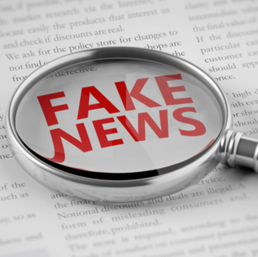 A page from a book that has the words 'Fake News' in red bold text enlarged by a magnifying glass.