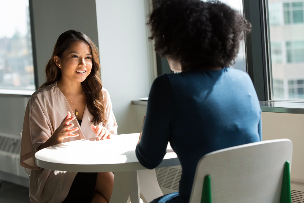 Two people talking at a table.
